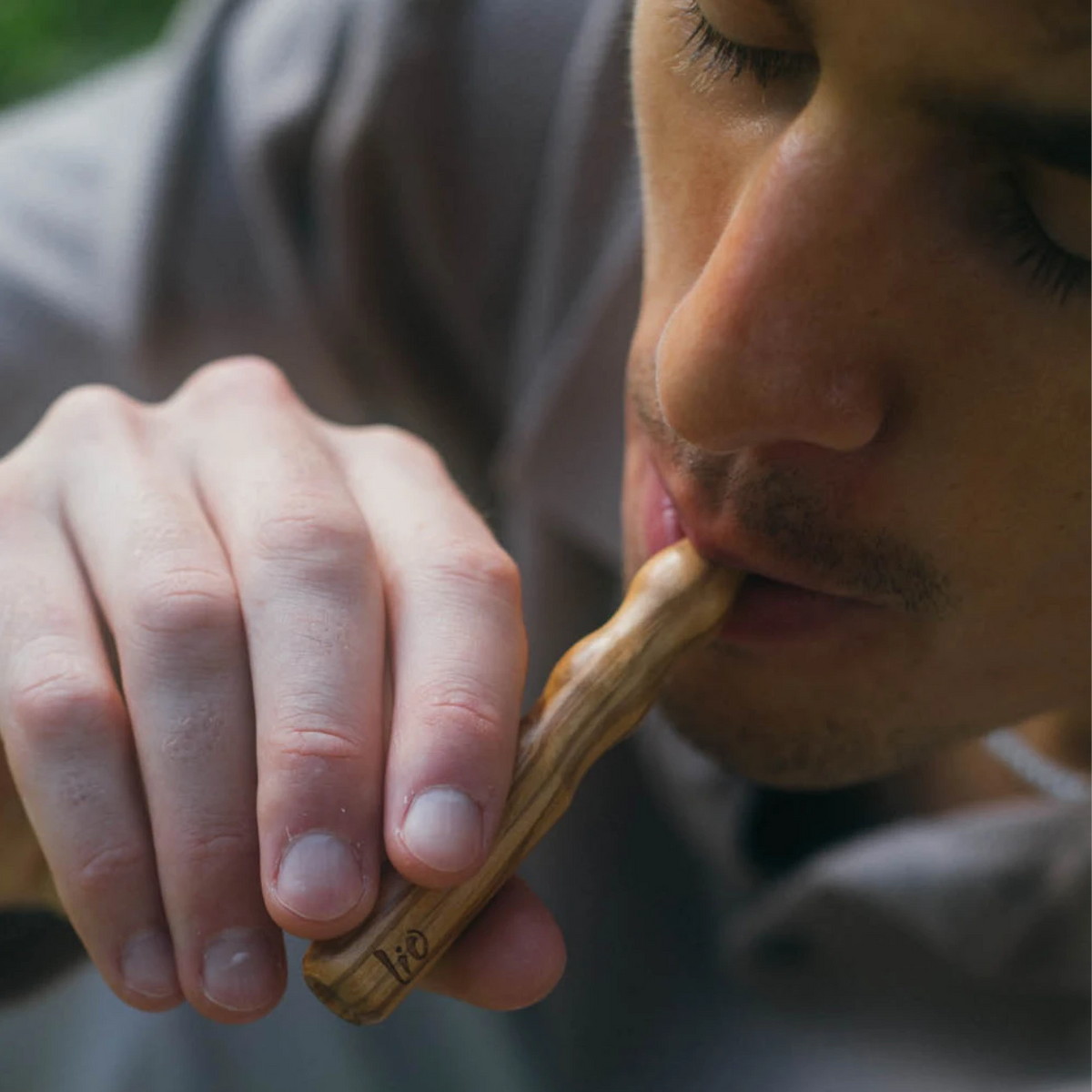 Homme prenant une bouffée d'un diffuseur Lio en bois d'olivier